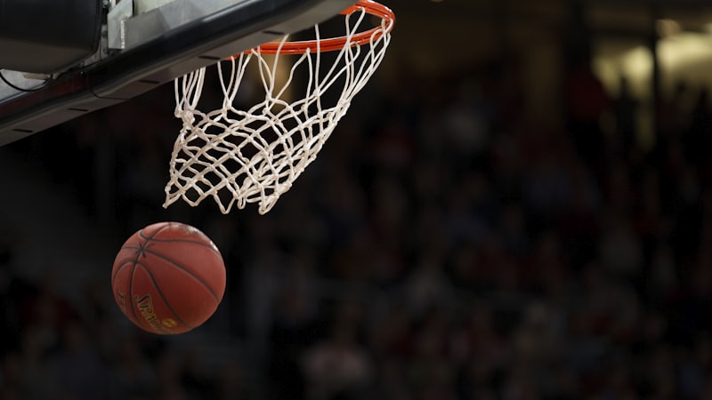 NBA总决赛第七场在灯火通明的球馆内进行，球员高高跃起投篮